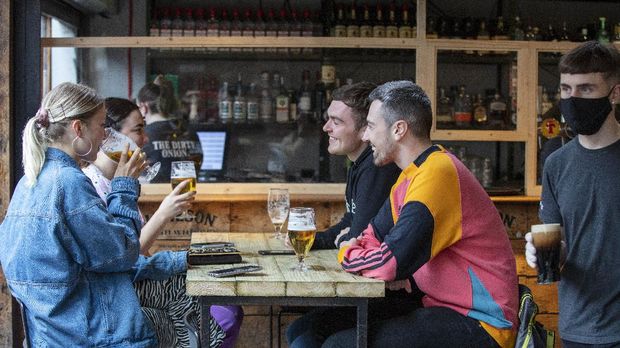 People enjoy a drink inside the Dirty Onion in Belfast on July 3, 2020, as pubs open their doors after the enforced closure due to the coronavirus pandemic. - Pubs, cafes, restaurants and hotels in Northern Ireland are permitted to reopen from Friday as relaxations of the coronavirus restrictions continue. (Photo by Paul Faith / AFP)