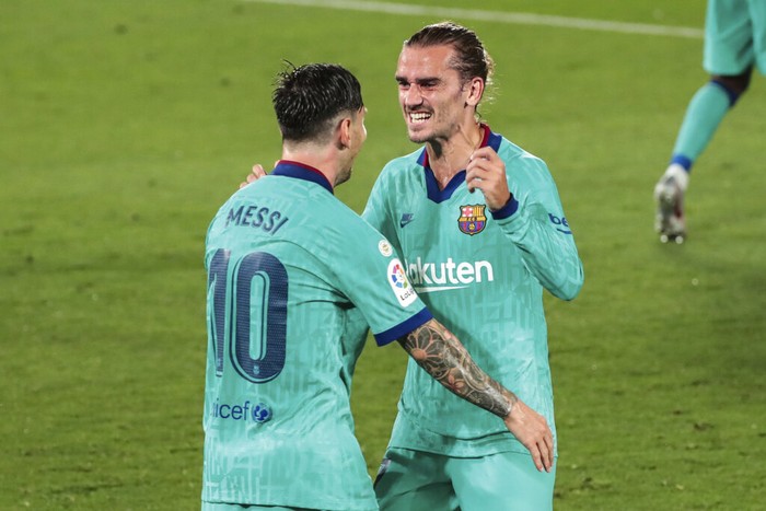 Barcelonas Antoine Griezmann, right, is congratulated by teammate Lionel Messi after scoring his side third goal during the Spanish La Liga soccer match between FC Barcelona and Villareal at La Ceramica stadium in Villareal, Spain, Sunday, July 5, 2020. (AP Photo/Jose Miguel Fernandez)