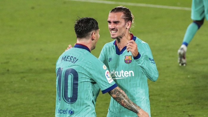 Barcelonas Antoine Griezmann, right, is congratulated by teammate Lionel Messi after scoring his side third goal during the Spanish La Liga soccer match between FC Barcelona and Villareal at La Ceramica stadium in Villareal, Spain, Sunday, July 5, 2020. (AP Photo/Jose Miguel Fernandez)