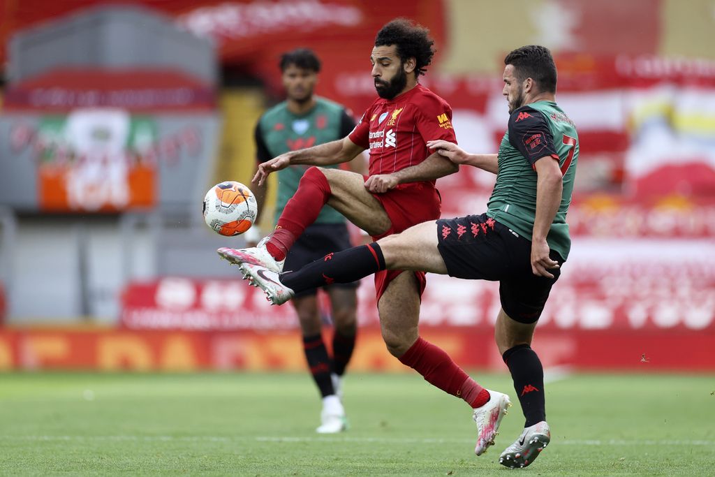 Liverpool's Mohamed Salah vies for the ball with Aston Villa's John McGinn, right, during the English Premier League soccer match between Liverpool and Aston Villa at Anfield Stadium in Liverpool, England, Sunday, July 5, 2020. (Carl Recine/Pool via AP)