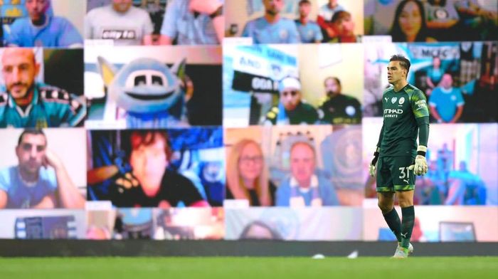 Ederson MANCHESTER, ENGLAND - JULY 02: Ederson of Manchester City looks on in front of the Manchester City fan wall during the Premier League match between Manchester City and Liverpool FC at Etihad Stadium on July 02, 2020 in Manchester, England. Football Stadiums around Europe remain empty due to the Coronavirus Pandemic as Government social distancing laws prohibit fans inside venues resulting in all fixtures being played behind closed doors. (Photo by Laurence Griffiths/Getty Images)