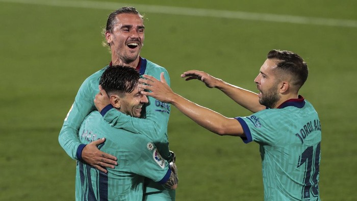 Barcelonas Antoine Griezmann, top, is congratulated by teammate Lionel Messi, left, and Jordi Alba, right, after scoring his side third goal during the Spanish La Liga soccer match between FC Barcelona and Villareal at La Ceramica stadium in Villareal, Spain, Sunday, July 5, 2020. (AP Photo/Jose Miguel Fernandez)