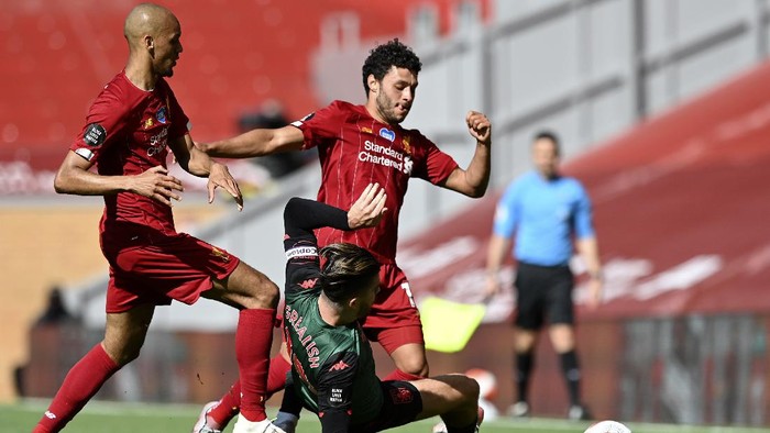 Aston Villas Jack Grealish, on the ground, tackles Liverpools Alex Oxlade-Chamberlain during the English Premier League soccer match between Liverpool and Aston Villa at Anfield Stadium in Liverpool, England, Sunday, July 5, 2020. (Shaun Botterill/Pool via AP)