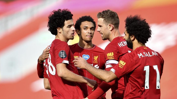 Liverpools Curtis Jones, left, celebrates after scoring his sides second goal during the English Premier League soccer match between Liverpool and Aston Villa at Anfield Stadium in Liverpool, England, Sunday, July 5, 2020. (Paul Ellis/Pool via AP)