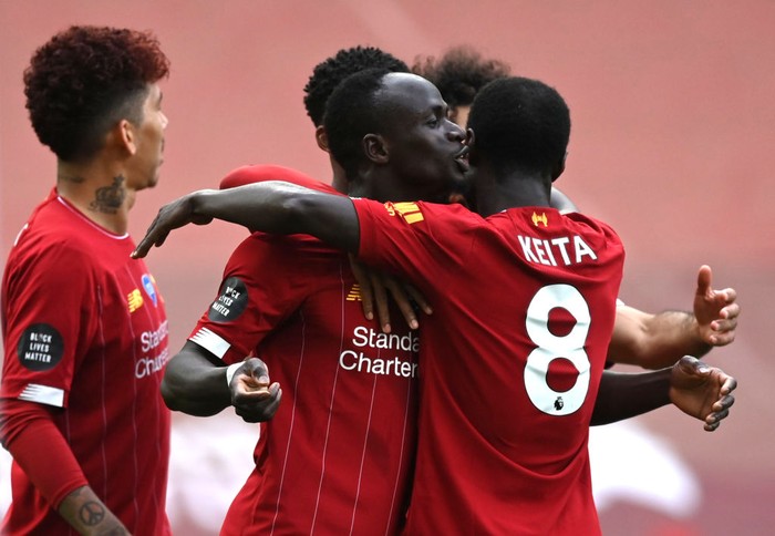 LIVERPOOL, ENGLAND - JULY 05: Sadio Mane of Liverpool celebrates with teammate Naby Keita after scoring his teams first goal during the Premier League match between Liverpool FC and Aston Villa at Anfield on July 05, 2020 in Liverpool, England.Football Stadiums around Europe remain empty due to the Coronavirus Pandemic as Government social distancing laws prohibit fans inside venues resulting in games being played behind closed doors. (Photo by Shaun Botterill/Getty Images)