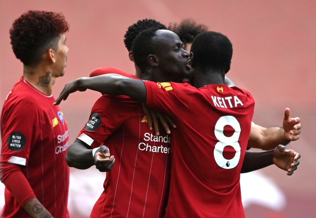 LIVERPOOL, ENGLAND - JULY 05: Sadio Mane of Liverpool celebrates with teammate Naby Keita after scoring his team's first goal during the Premier League match between Liverpool FC and Aston Villa at Anfield on July 05, 2020 in Liverpool, England.Football Stadiums around Europe remain empty due to the Coronavirus Pandemic as Government social distancing laws prohibit fans inside venues resulting in games being played behind closed doors. (Photo by Shaun Botterill/Getty Images)