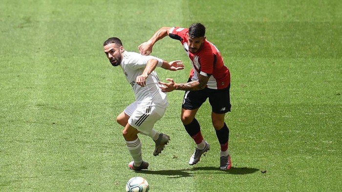 BILBAO, SPAIN - JULY 05: Dani Carvajal of Real Madrid is challenged by Yuri Berchiche of Athletic Club during the La Liga match between Athletic Club and Real Madrid CF at San Mames Stadium on July 05, 2020 in Bilbao, Spain. Football Stadiums around Europe remain empty due to the Coronavirus Pandemic as Government social distancing laws prohibit fans inside venues resulting in all fixtures being played behind closed doors. (Photo by Juan Manuel Serrano Arce/Getty Images)