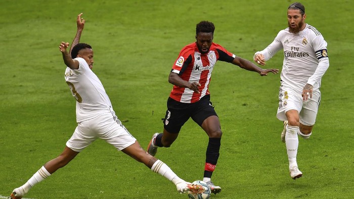 Athletic Bilbaos Inaki Williams, center, duels for the ball with Real Madrids Eder Militao, left, and Real Madrids Sergio Ramos during the Spanish La Liga soccer match between Athletic Club and Real Madrid at the San Manes stadium in Bilbao, Spain, Sunday, July 5, 2020. (AP Photo/Alvaro Barrientos)