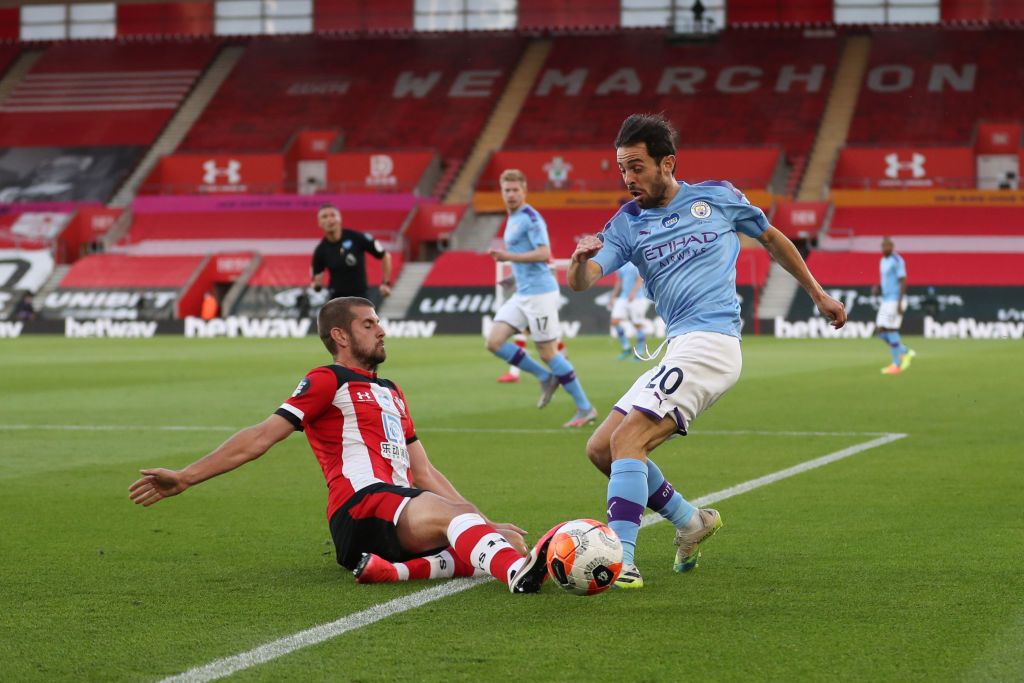 SOUTHAMPTON, ENGLAND - JULY 05: Jack Stephens of Southampton tackles Bernardo Silva of Manchester City during the Premier League match between Southampton FC and Manchester City at St Mary's Stadium on July 05, 2020 in Southampton, England. Football Stadiums around Europe remain empty due to the Coronavirus Pandemic as Government social distancing laws prohibit fans inside venues resulting in games being played behind closed doors. (Photo by Catherine Ivill/Getty Images)