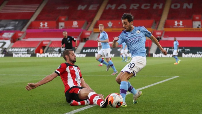 SOUTHAMPTON, ENGLAND - JULY 05: Jack Stephens of Southampton tackles Bernardo Silva of Manchester City during the Premier League match between Southampton FC and Manchester City at St Marys Stadium on July 05, 2020 in Southampton, England. Football Stadiums around Europe remain empty due to the Coronavirus Pandemic as Government social distancing laws prohibit fans inside venues resulting in games being played behind closed doors. (Photo by Catherine Ivill/Getty Images)