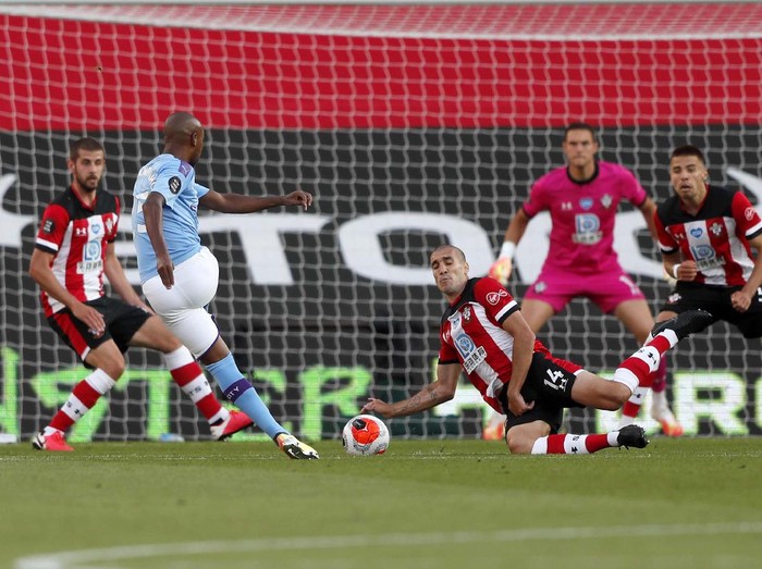 Southampton's Che Adams, second left, is congratulated by teammates after scoring his team's first goal during the English Premier League soccer match between Southampton and Manchester City at St. Mary's Stadium in Southampton, England, Sunday, July 5, 2020. (AP Photo/Frank Augstein,Pool)