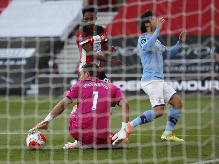 Southampton's Che Adams, second left, is congratulated by teammates after scoring his team's first goal during the English Premier League soccer match between Southampton and Manchester City at St. Mary's Stadium in Southampton, England, Sunday, July 5, 2020. (AP Photo/Frank Augstein,Pool)