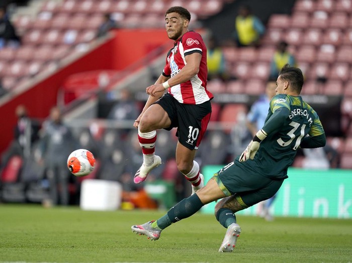 Southampton's Che Adams, second left, is congratulated by teammates after scoring his team's first goal during the English Premier League soccer match between Southampton and Manchester City at St. Mary's Stadium in Southampton, England, Sunday, July 5, 2020. (AP Photo/Frank Augstein,Pool)