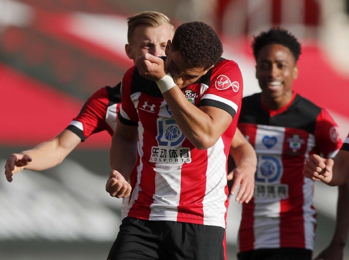 Southampton's Che Adams, second left, is congratulated by teammates after scoring his team's first goal during the English Premier League soccer match between Southampton and Manchester City at St. Mary's Stadium in Southampton, England, Sunday, July 5, 2020. (AP Photo/Frank Augstein,Pool)