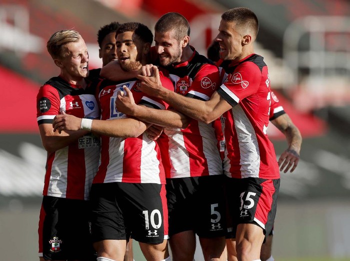 Southampton's Che Adams, second left, is congratulated by teammates after scoring his team's first goal during the English Premier League soccer match between Southampton and Manchester City at St. Mary's Stadium in Southampton, England, Sunday, July 5, 2020. (AP Photo/Frank Augstein,Pool)