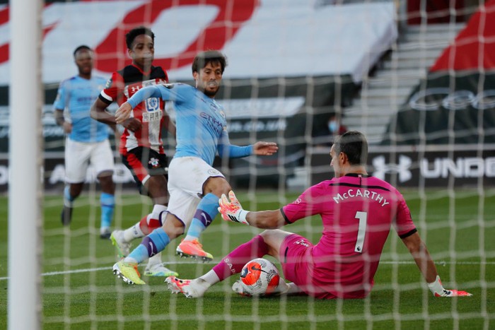 SOUTHAMPTON, ENGLAND - JULY 05: Alex McCarthy of Southampton saves from David Silva of Manchester City during the Premier League match between Southampton FC and Manchester City at St Marys Stadium on July 05, 2020 in Southampton, England. Football Stadiums around Europe remain empty due to the Coronavirus Pandemic as Government social distancing laws prohibit fans inside venues resulting in games being played behind closed doors. (Photo by Frank Augstein/Pool via Getty Images)