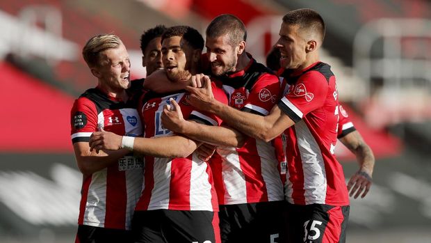Southampton's Che Adams, second left, is congratulated by teammates after scoring his team's first goal during the English Premier League soccer match between Southampton and Manchester City at St. Mary's Stadium in Southampton, England, Sunday, July 5, 2020. (AP Photo/Frank Augstein,Pool)