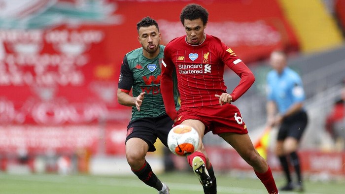 Liverpools Trent Alexander-Arnold controls the ball next to Aston Villas Trezeguet, left, during the English Premier League soccer match between Liverpool and Aston Villa at Anfield Stadium in Liverpool, England, Sunday, July 5, 2020. (Carl Recine/Pool via AP)