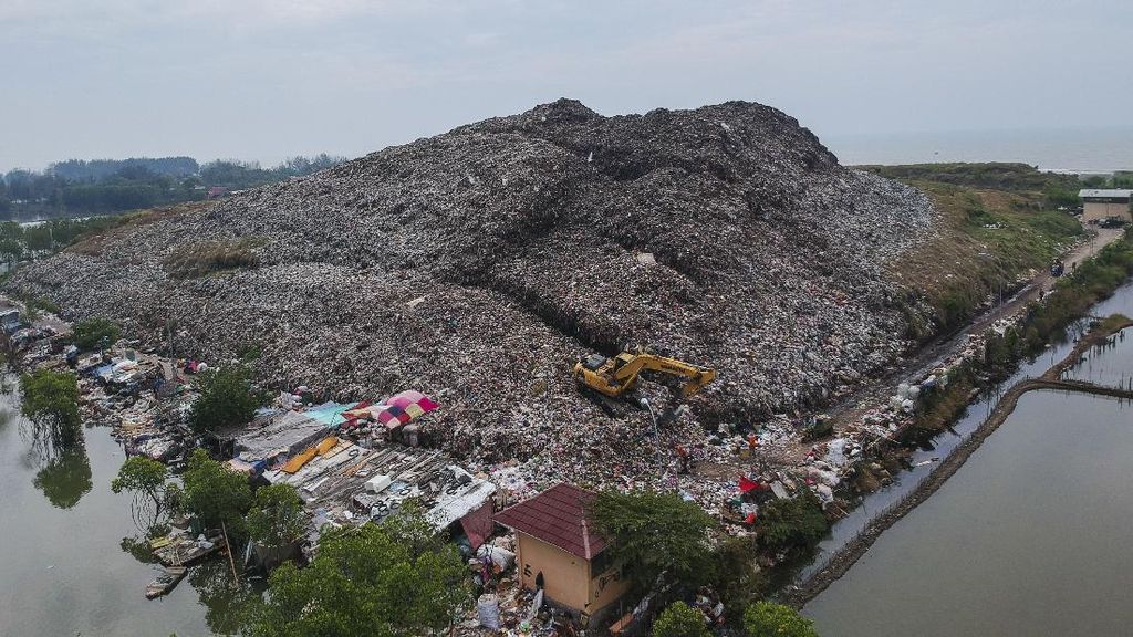 TUMPUKAN SAMPAH MELEBIHI KAPASITAS Sebuah alat berat menyortir tumpukan sampah yang menggunung di Tempat Pembuangan Akhir (TPA) Degayu, Pekalongan, Jawa Tengah, Senin (6/7/2020). Menurut Dinas Lingkungan Hidup setempat, tumpukan sampah di TPA tersebut sudah melebihi batas kapasitas dengan ketinggian tumpukan sampah mencapai sekitar 17 meter, melebihi batas standart yang ditentukan yaitu di bawah 10 meter dengan produksi sampah rata-rata mencapai 125 ton per hari. ANTARA FOTO/Harviyan Perdana Putra/hp.