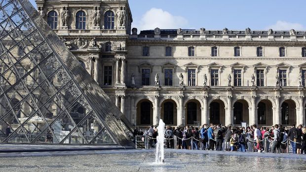 Visitors wait in the Louvre Museum courtyard prior to visit the museum, in Paris, Monday, July 6, 2020. The home of the world's most famous portrait, the Louvre Museum in Paris, reopened Monday after a four-month coronavirus lockdown. (AP Photo/ Thibault Camus)