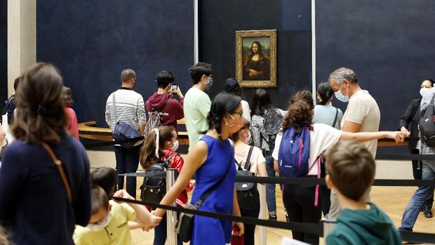 Visitors wait to see the Leonardo da Vinci's painting Mona Lisa, in Paris, Monday, July 6, 2020. The home of the world's most famous portrait, the Louvre Museum in Paris, reopened Monday after a four-month coronavirus lockdown. (AP Photo/ Thibault Camus)