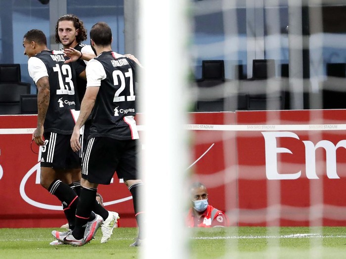 AC Milan's Rafael Leao, left, celebrates with his teammate Ismael Bennacer after scoring his side's 3rd goal during the Serie A soccer match between AC Milan and Juventus at the Milan San Siro Stadium, Italy, Tuesday, July 7, 2020. (Spada/LaPresse via AP)
