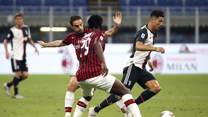 Juventus Cristiano Ronaldo, right, controls the ball by AC Milans Giacomo Bonaventura, left, and Franck Kessie during the Serie A soccer match between AC Milan and Juventus at the San Siro stadium, in Milan, Italy, Tuesday, July 7, 2020. (AP Photo/Antonio Calanni)