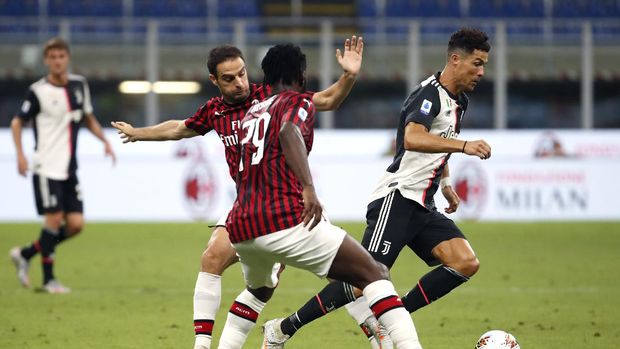Juventus' Cristiano Ronaldo, right, controls the ball by AC Milan's Giacomo Bonaventura, left, and Franck Kessie during the Serie A soccer match between AC Milan and Juventus at the San Siro stadium, in Milan, Italy, Tuesday, July 7, 2020. (AP Photo/Antonio Calanni)