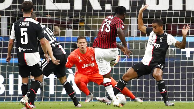 AC Milan's Franck Kessie, center, scores against Juventus during the Serie A soccer match between AC Milan and Juventus at the San Siro stadium, in Milan, Italy, Tuesday, July 7, 2020. (AP Photo/Antonio Calanni)