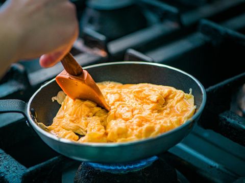 Preparing scrambled eggs in a pan, close-up.