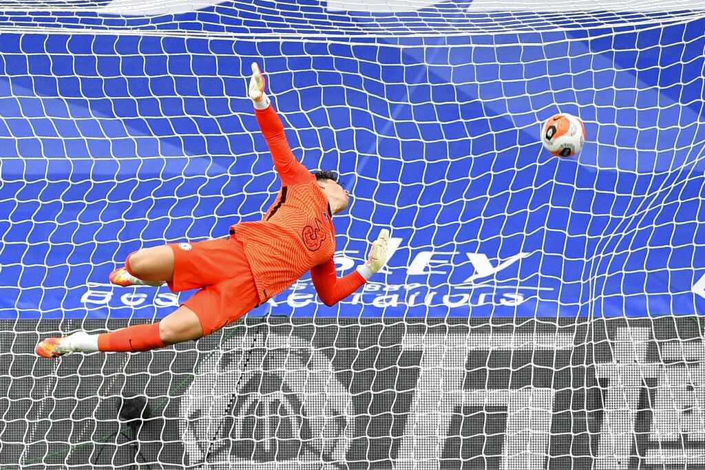 Chelsea's goalkeeper Kepa Arrizabalaga fails to save the ball as Crystal Palace's Wilfried Zaha scores his side's opening goal during the English Premier League soccer match between Crystal Palace and Burnley at Selhurst Park, in London, England, Tuesday, July 7, 2020. (Justin Tallis/Pool via AP)
