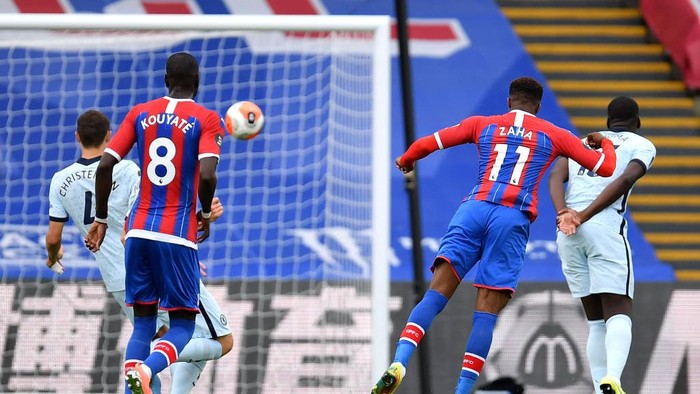 LONDON, ENGLAND - JULY 07: Wilfried Zaha of Crystal Palace scores his teams first goal during the Premier League match between Crystal Palace and Chelsea FC at Selhurst Park on July 07, 2020 in London, England. Football Stadiums around Europe remain empty due to the Coronavirus Pandemic as Government social distancing laws prohibit fans inside venues resulting in all fixtures being played behind closed doors. (Photo by Justin Setterfield/Getty Images)