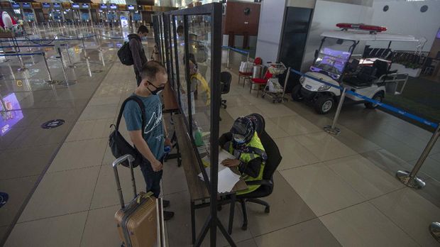 Calon penumpang menyerahkan dokumen hasil tes rapid negatif COVID-19 kepada petugas di Terminal 3 Bandara Internasional Soekarno-Hatta, Tangerang, Banten, Kamis (9/7/2020). Meski penerbangan telah kembali dibuka dengan persyaratan seperti penumpang harus dengan memiliki hasil rapid atau PCR test negatif COVID-19, suasana di Bandara Soekarno Hatta masih terpantau sepi. ANTARA FOTO/Aditya Pradana Putra/aww.