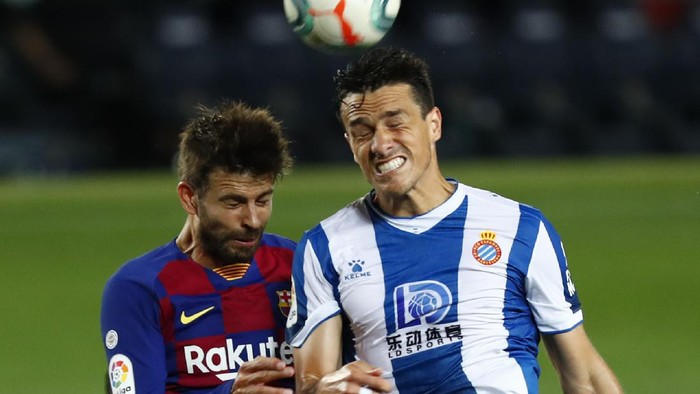 Barcelonas Gerard Pique fights for the ball against Espanyols Bernardo Espinosa during the Spanish La Liga soccer match between FC Barcelona and RCD Espanyol at the Camp Nou stadium in Barcelona, Spain, Wednesday, July 8, 2020. (AP Photo/Joan Monfort)