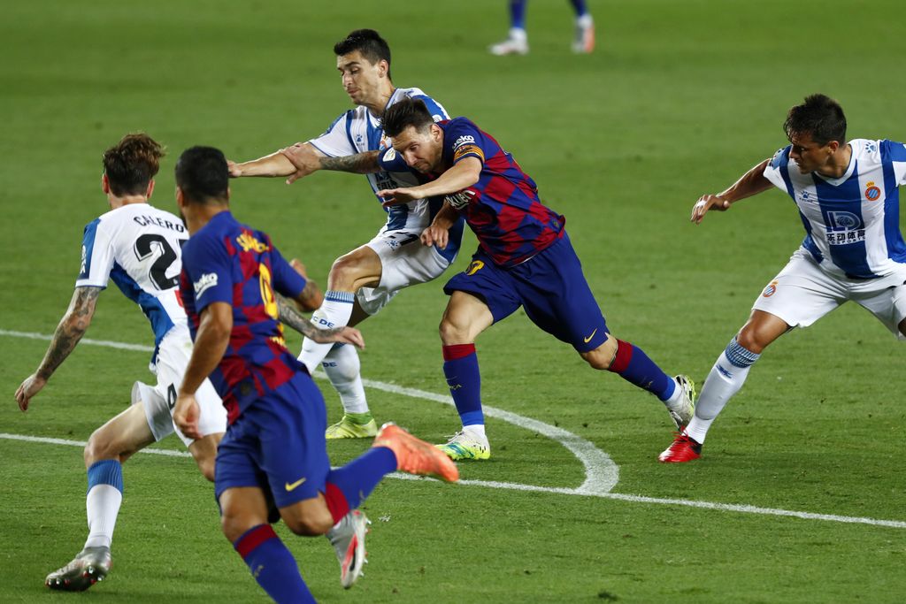 Barcelona's Lionel Messi runs for the ball next to Luis Suarez, against Espanyol's Marc Roca, Fernando Calero and Bernardo Espinosa, left, during the Spanish La Liga soccer match between FC Barcelona and RCD Espanyol at the Camp Nou stadium in Barcelona, Spain, Wednesday, July 8, 2020. (AP Photo/Joan Monfort)