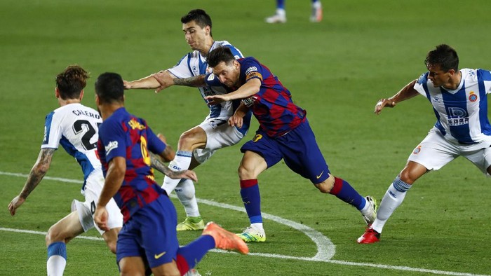 Barcelonas Lionel Messi runs for the ball next to Luis Suarez, against Espanyols Marc Roca, Fernando Calero and Bernardo Espinosa, left, during the Spanish La Liga soccer match between FC Barcelona and RCD Espanyol at the Camp Nou stadium in Barcelona, Spain, Wednesday, July 8, 2020. (AP Photo/Joan Monfort)