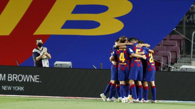 Barcelona's Luis Suarez celebrates with teammates scoring the opening goal during the Spanish La Liga soccer match between FC Barcelona and RCD Espanyol at the Camp Nou stadium in Barcelona, Spain, Wednesday, July 8, 2020. (AP Photo/Joan Monfort)