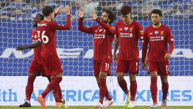 Liverpool's Mohamed Salah, centre, is congratulated by teammates after scoring his team's first goal during the English Premier League soccer match between Brighton and Liverpool at Falmer Stadium in Brighton, England, Wednesday, July 8, 2020. (AP Photo/Catherine Ivill,Pool)