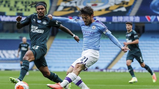 Manchester City's David Silva shots past Newcastle's Valentino Lazaro, left, during the English Premier League soccer match between Manchester City and Newcastle at the Ethiad Stadium in Manchester, England, Wednesday, July 8, 2020. (Lee Smith/Pool via AP)