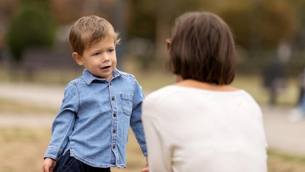 Cute little boy complaining to mother outdoors. Selective focus