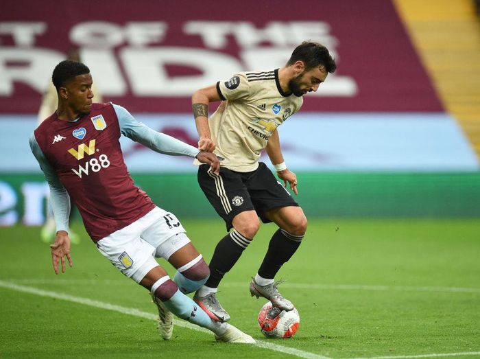1255259915 BIRMINGHAM, ENGLAND - JULY 09: Bruno Fernandes of Manchester United is fouled by Ezri Konsa Ngoyo of Aston Villa and a penalty is awarded during the Premier League match between Aston Villa and Manchester United at Villa Park on July 09, 2020 in Birmingham, England. Football Stadiums around Europe remain empty due to the Coronavirus Pandemic as Government social distancing laws prohibit fans inside venues resulting in all fixtures being played behind closed doors. (Photo by Oli Scarff/Pool via Getty Images)