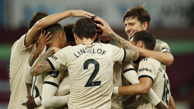 Manchester United's Paul Pogba, obscured, is congratulated by teammates after scoring his team's third goal during the English Premier League soccer match between Aston Villa and Manchester United at Villa Park in Birmingham, England, Thursday, July 9, 2020. (AP PhotoAndrew Boyers,Pool)