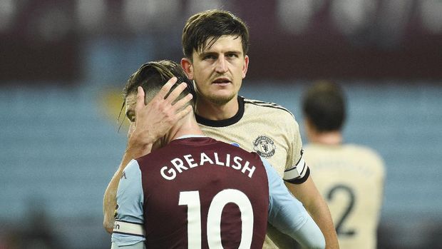 Manchester United's Harry Maguire, right, embraces Aston Villa's Jack Grealish after the English Premier League soccer match between Aston Villa and Manchester United at Villa Park in Birmingham, England, Thursday, July 9, 2020. (AP Photo/Oli Scarff,Pool)