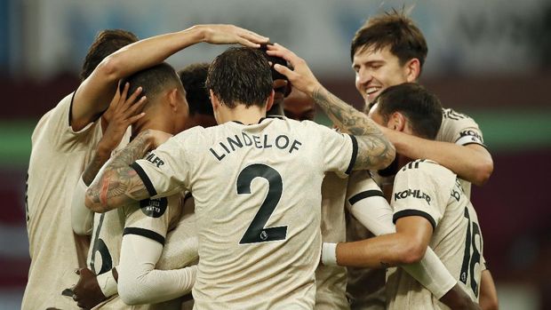 Manchester United's Paul Pogba, obscured, is congratulated by teammates after scoring his team's third goal during the English Premier League soccer match between Aston Villa and Manchester United at Villa Park in Birmingham, England, Thursday, July 9, 2020. (AP PhotoAndrew Boyers,Pool)