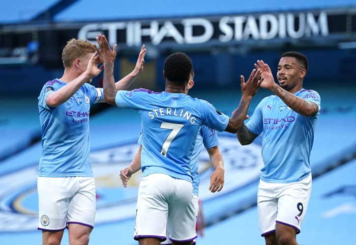 MANCHESTER, ENGLAND - JULY 02: Raheem Sterling of Manchester City celebrates with Kevin De Bruyne and Gabriel Jesus after scoring his teams second goal during the Premier League match between Manchester City and Liverpool FC at Etihad Stadium on July 02, 2020 in Manchester, England. Football Stadiums around Europe remain empty due to the Coronavirus Pandemic as Government social distancing laws prohibit fans inside venues resulting in all fixtures being played behind closed doors. (Photo by Dave Thompson/Pool via Getty Images)