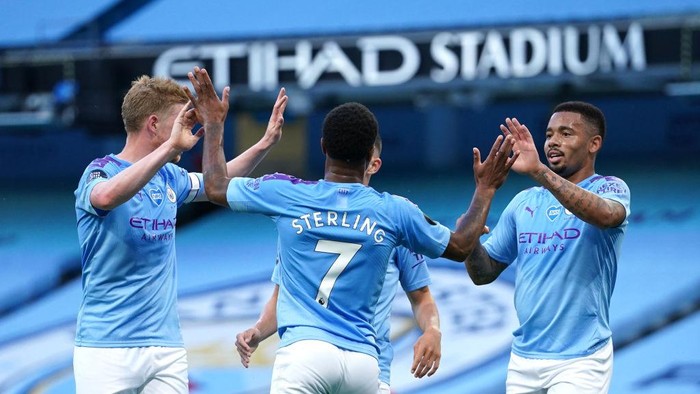 MANCHESTER, ENGLAND - JULY 02: Raheem Sterling of Manchester City celebrates with Kevin De Bruyne and Gabriel Jesus after scoring his teams second goal during the Premier League match between Manchester City and Liverpool FC at Etihad Stadium on July 02, 2020 in Manchester, England. Football Stadiums around Europe remain empty due to the Coronavirus Pandemic as Government social distancing laws prohibit fans inside venues resulting in all fixtures being played behind closed doors. (Photo by Dave Thompson/Pool via Getty Images)