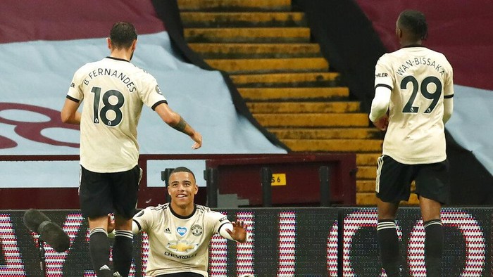 Manchester Uniteds Mason Greenwood celebrates with teammates Bruno Fernandes, left, and Aaron Wan-Bissaka, right, after scoring his teams second goal during the English Premier League soccer match between Aston Villa and Manchester United at Villa Park in Birmingham, England, Thursday, July 9, 2020. (AP PhotoAndrew Boyers,Pool)
