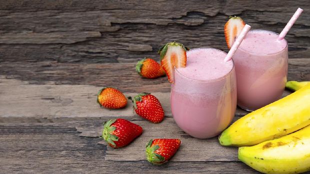 Strawberry mix banana smoothies red colorful fruit juice milkshake blend beverage healthy high protein the taste yummy In glass drink episode morning on wood background.