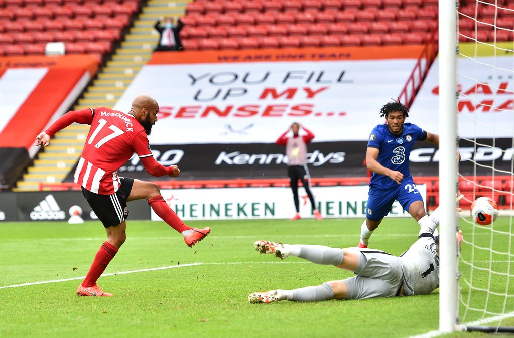 SHEFFIELD, ENGLAND - JULY 11: David McGoldrick of Sheffield United scores his team's first goal past Kepa Arrizabalaga of Chelsea during the Premier League match between Sheffield United and Chelsea FC at Bramall Lane on July 11, 2020 in Sheffield, England. Football Stadiums around Europe remain empty due to the Coronavirus Pandemic as Government social distancing laws prohibit fans inside venues resulting in all fixtures being played behind closed doors. (Photo by Peter Powell/Pool via Getty Images)
