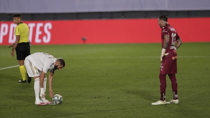 Real Madrids Karim Benzema, left, prepares to shoot a penalty, as Deportivo Alaves goalkeeper Roberto, looks on during the Spanish La Liga soccer match between Real Madrid and Deportivo Alaves at the Alfredo di Stefano stadium in Madrid, Spain, Friday, July 10, 2020. Benzema went on to score the penalty. (AP Photo/Bernat Armangue)